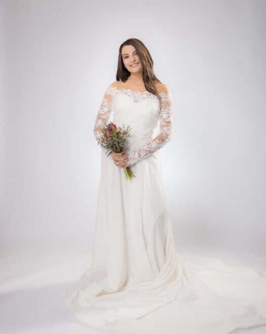 Wedding dress with clean lines and removable lace jacket at bridal shop in west bend Wisconsin 